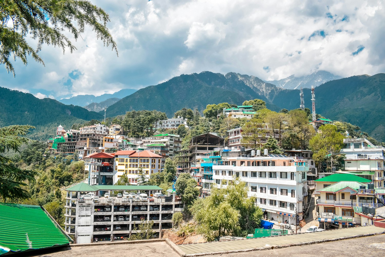 McLeod Ganj hillside buildings beneath the snow-covered Dhauladhar mountains near Dharamshala